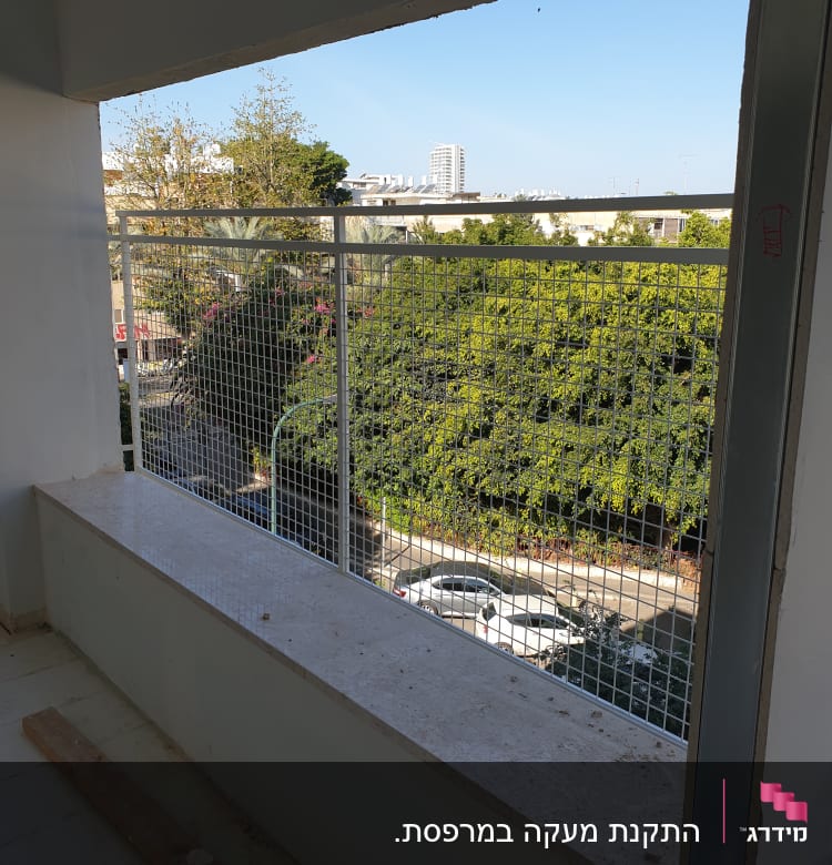 מעקה מתכת עם רשת על מרפסת